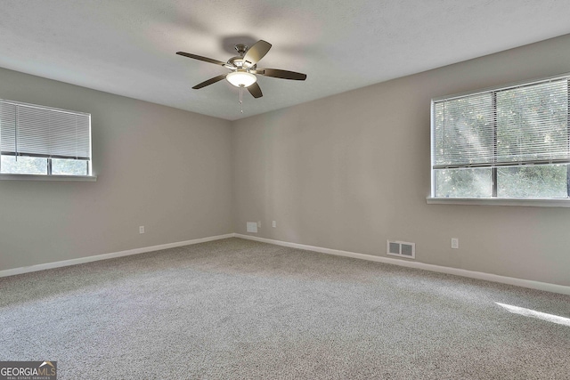 carpeted spare room featuring ceiling fan and a textured ceiling