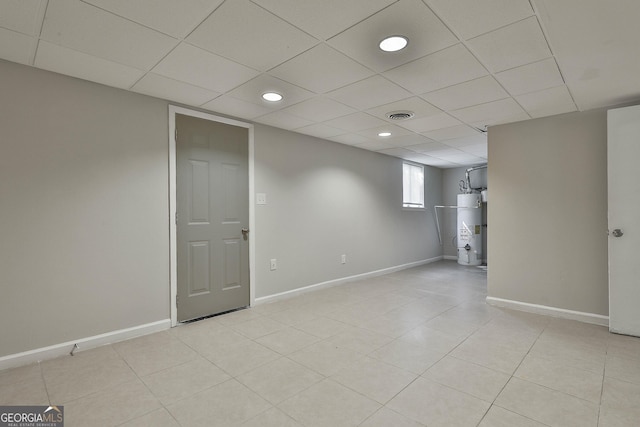 basement with strapped water heater and a drop ceiling