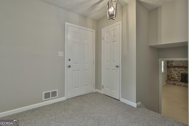 entryway with carpet floors and a textured ceiling