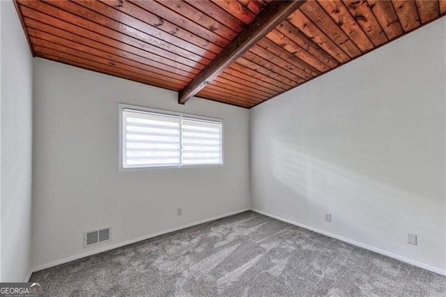 empty room featuring beam ceiling, carpet floors, and wooden ceiling