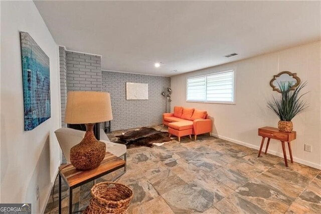 sitting room featuring brick wall