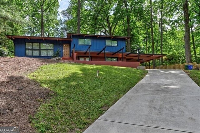 view of front of house with a carport and a front lawn