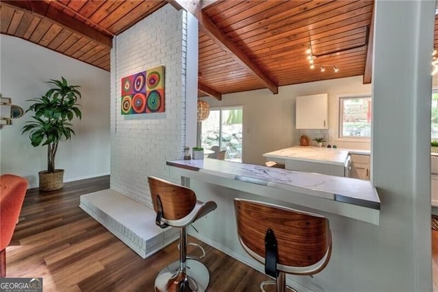 bar featuring lofted ceiling with beams, dark hardwood / wood-style flooring, white cabinetry, and wood ceiling