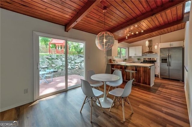 dining space with vaulted ceiling with beams, hardwood / wood-style flooring, and wooden ceiling