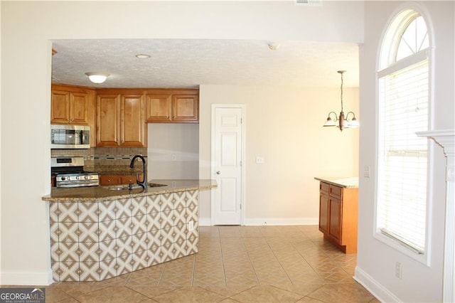 kitchen featuring stainless steel appliances, tasteful backsplash, sink, hanging light fixtures, and light tile patterned floors