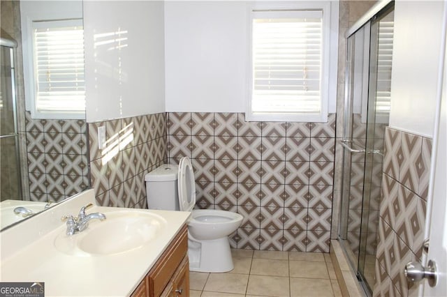 bathroom with toilet, vanity, tile patterned flooring, and a healthy amount of sunlight