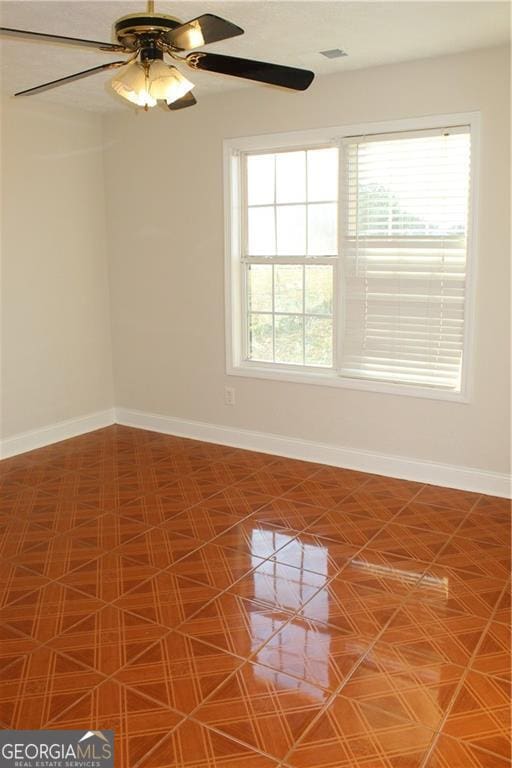 unfurnished room featuring ceiling fan and a wealth of natural light