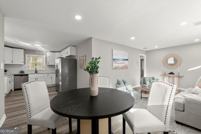 dining room with hardwood / wood-style floors and sink