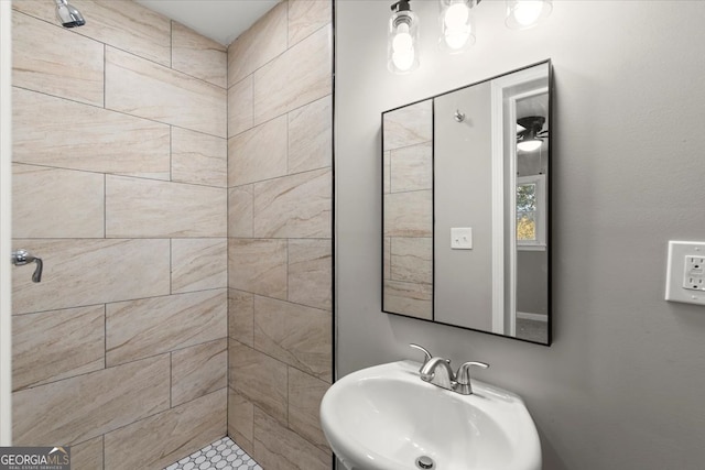 bathroom with tiled shower and sink