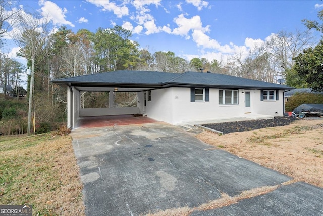 single story home with a front lawn and a carport