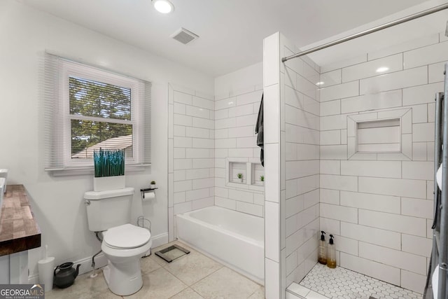 bathroom featuring tile patterned floors, toilet, and a tile shower