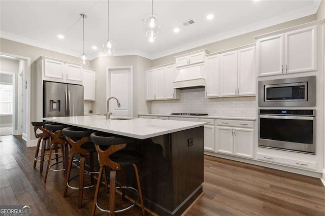 kitchen featuring white cabinets, appliances with stainless steel finishes, and decorative light fixtures