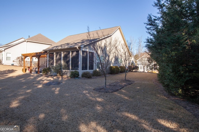 rear view of house featuring a sunroom and a pergola