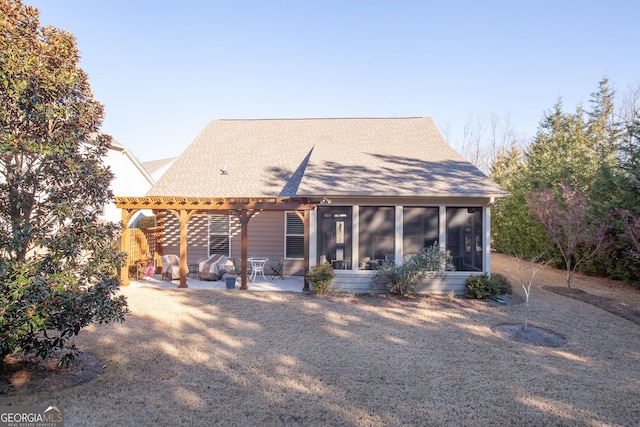 back of property with a sunroom, a pergola, and a patio