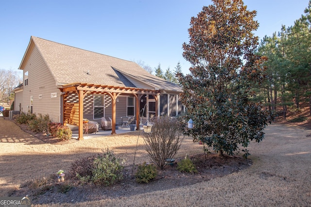 rear view of property with a patio, roof with shingles, and a pergola