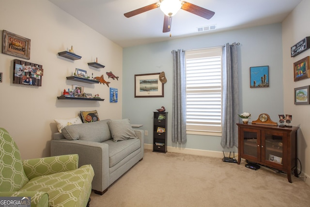 sitting room featuring light carpet, baseboards, visible vents, and ceiling fan