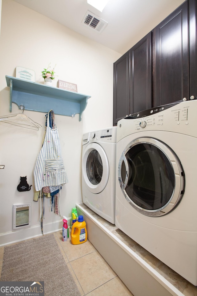 clothes washing area with cabinet space, tile patterned flooring, visible vents, and washer and dryer