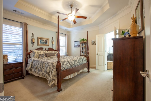 bedroom with light carpet, a raised ceiling, and visible vents