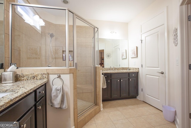 full bath with tile patterned flooring, a shower stall, and vanity