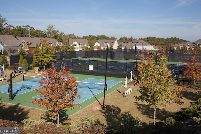 view of sport court with a residential view and fence