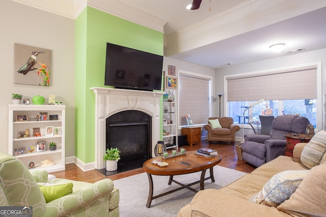 living room featuring ceiling fan, wood-type flooring, and ornamental molding