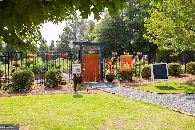 view of play area featuring a gate, fence, and a yard