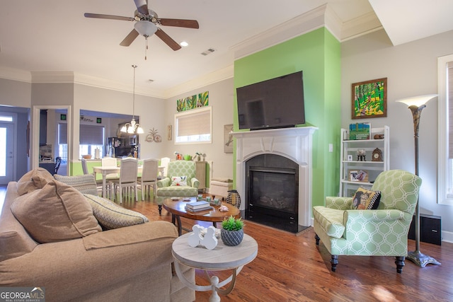 living room with a fireplace with flush hearth, wood finished floors, visible vents, and a healthy amount of sunlight