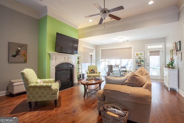 living room featuring baseboards, a fireplace, wood finished floors, and crown molding