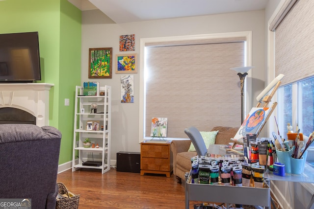 bedroom featuring a fireplace, wood finished floors, and baseboards