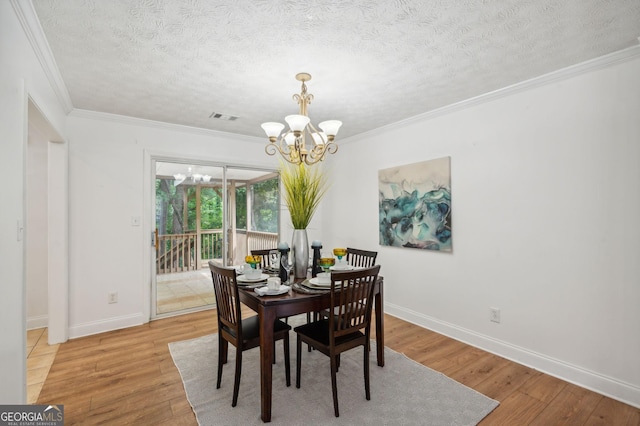 dining area with crown molding, a chandelier, a textured ceiling, and light wood-type flooring