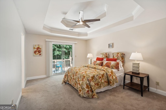 carpeted bedroom with ceiling fan, access to exterior, ornamental molding, and a tray ceiling