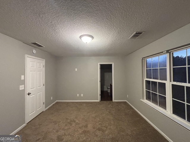 unfurnished room featuring a textured ceiling and carpet flooring