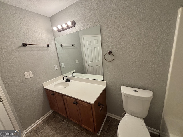 bathroom featuring toilet, a textured ceiling, tile patterned floors, and vanity