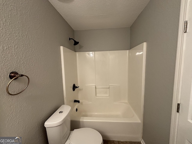 bathroom featuring toilet, a textured ceiling, and shower / bath combination