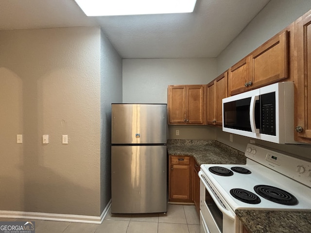 kitchen featuring white appliances and light tile patterned flooring