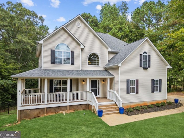 view of front of home featuring covered porch and a yard