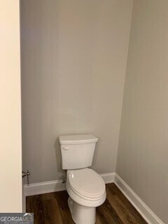 bathroom featuring toilet, baseboards, and wood finished floors