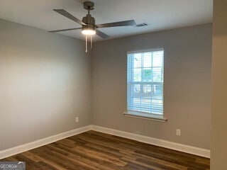 empty room featuring a ceiling fan, visible vents, baseboards, and dark wood-style flooring