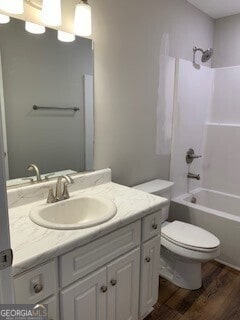 bathroom with vanity, tub / shower combination, wood finished floors, and toilet