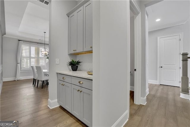 hallway with light hardwood / wood-style floors and a chandelier