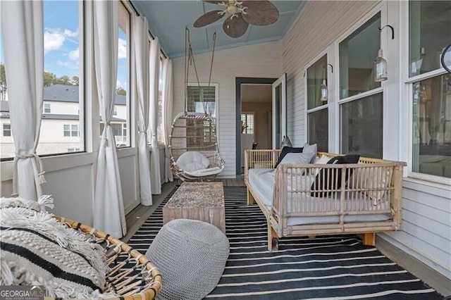 sunroom / solarium with lofted ceiling and ceiling fan