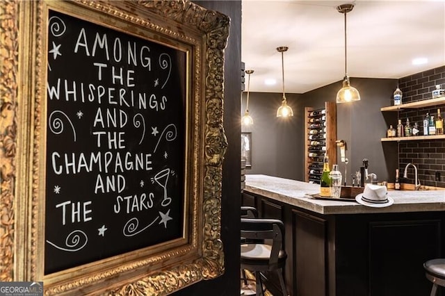 bar with sink, pendant lighting, and decorative backsplash