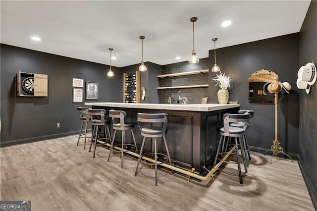 bar with decorative light fixtures and hardwood / wood-style flooring