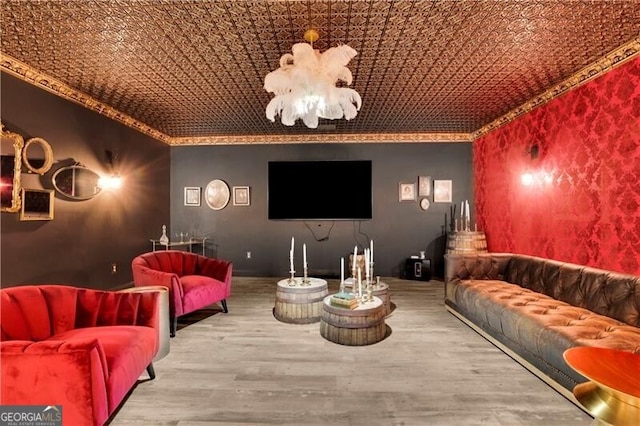 cinema featuring wood-type flooring, ornamental molding, and a chandelier