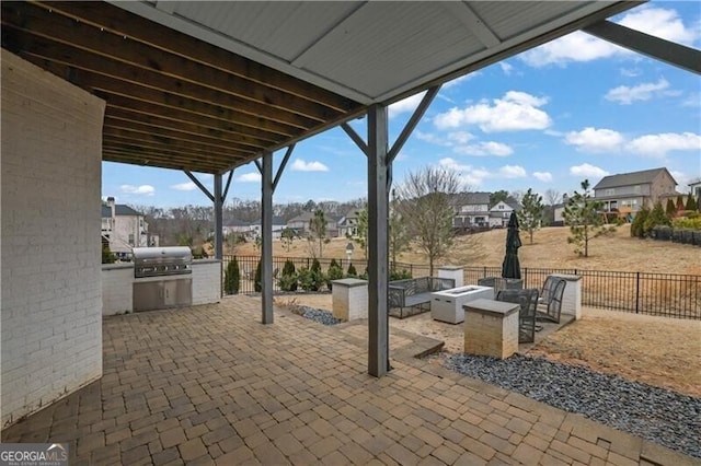 view of patio with a fire pit, grilling area, and exterior kitchen