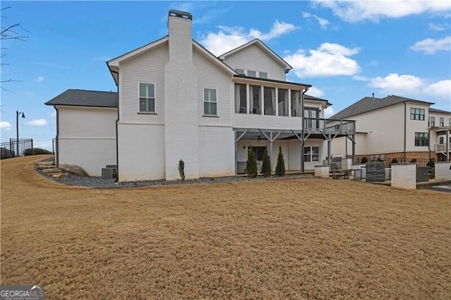 back of house with a sunroom, a yard, and cooling unit