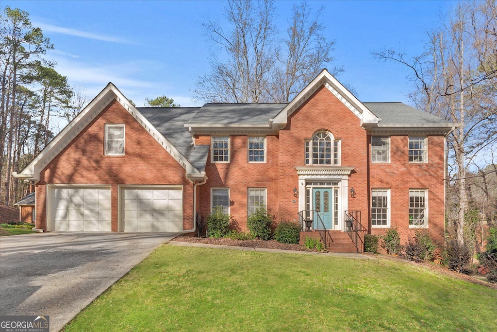 view of front of property featuring a front yard and a garage