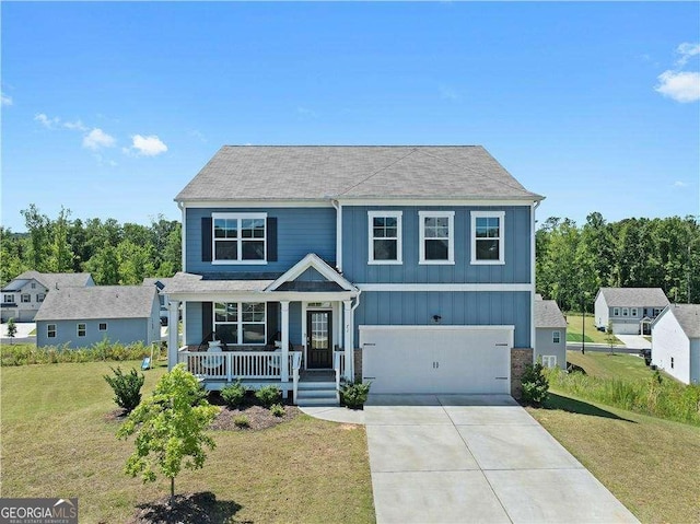 view of front of property featuring covered porch, a garage, and a front yard