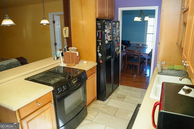 kitchen featuring pendant lighting, sink, light tile patterned floors, a notable chandelier, and black appliances