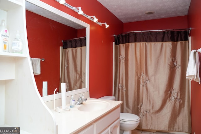 bathroom with vanity, a shower with curtain, toilet, and a textured ceiling